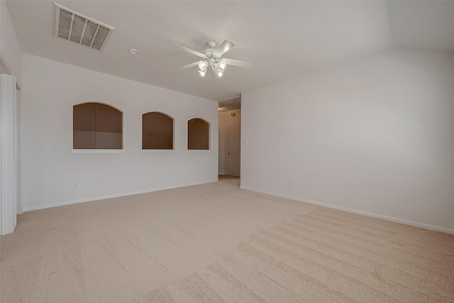 carpeted spare room with ceiling fan and vaulted ceiling