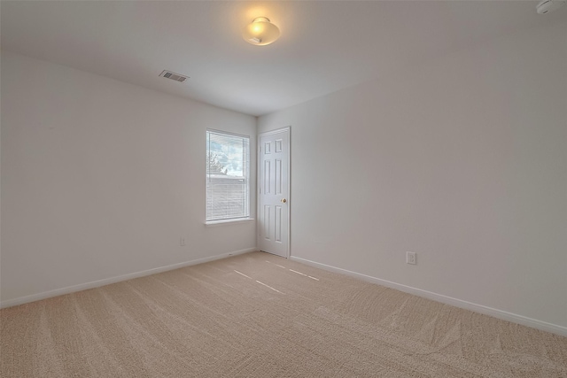 unfurnished room featuring light carpet