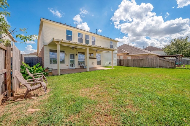 rear view of house with a yard, ceiling fan, and a patio area