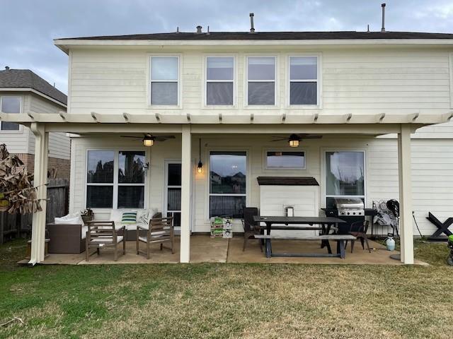 back of house featuring a patio area, outdoor lounge area, and a lawn