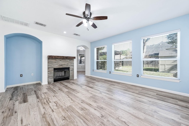 unfurnished living room with a fireplace, light wood-type flooring, and ceiling fan