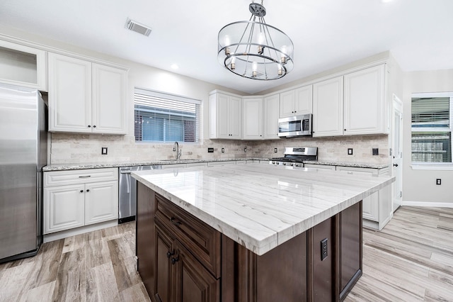 kitchen with white cabinets, appliances with stainless steel finishes, and a center island