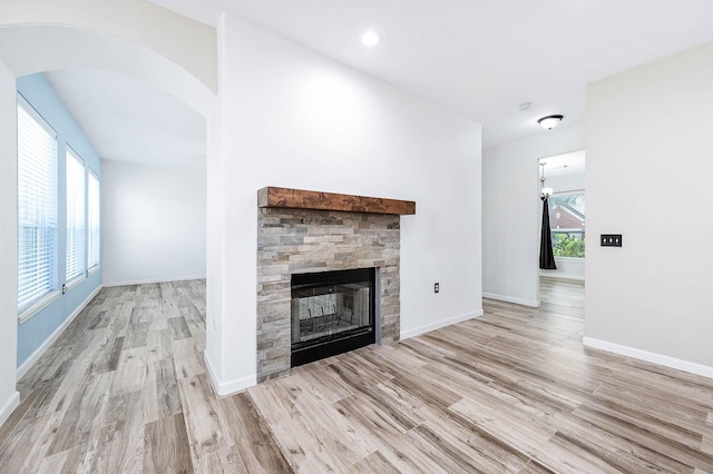 unfurnished living room with a fireplace, light hardwood / wood-style floors, and plenty of natural light