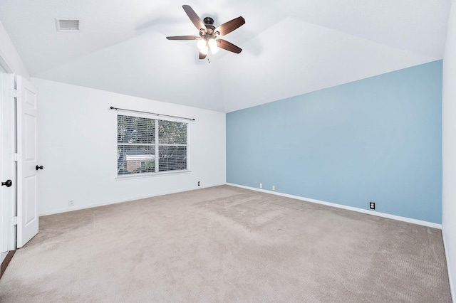 spare room with ceiling fan, light carpet, and vaulted ceiling