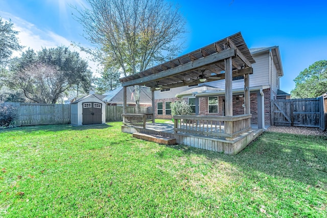 view of yard featuring a wooden deck, ceiling fan, and a storage shed