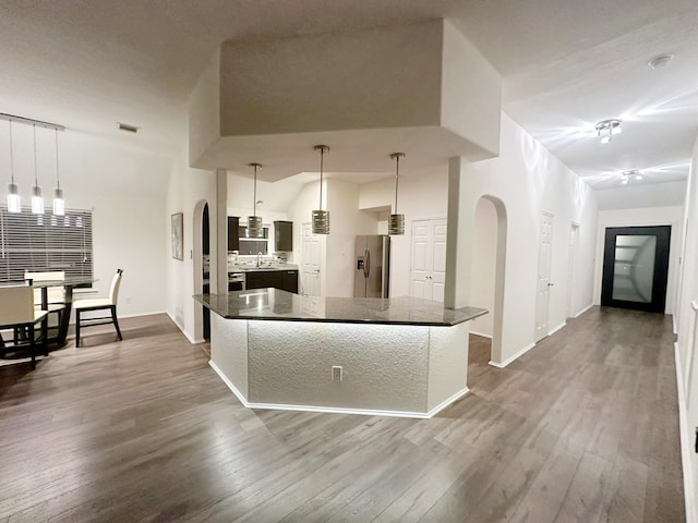 kitchen featuring lofted ceiling, sink, hanging light fixtures, dark hardwood / wood-style flooring, and stainless steel fridge with ice dispenser