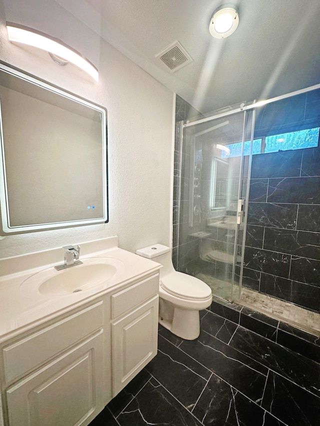 bathroom with vanity, toilet, and a shower with door