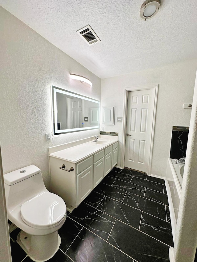 bathroom featuring a tub to relax in, vanity, a textured ceiling, and toilet