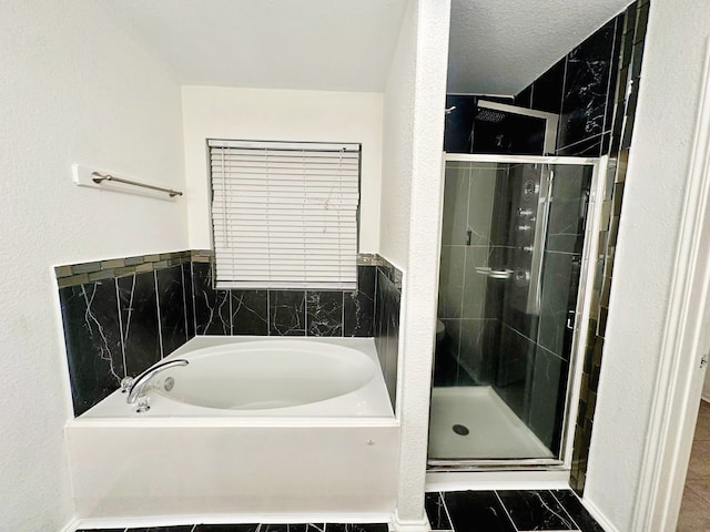 bathroom with separate shower and tub and a textured ceiling