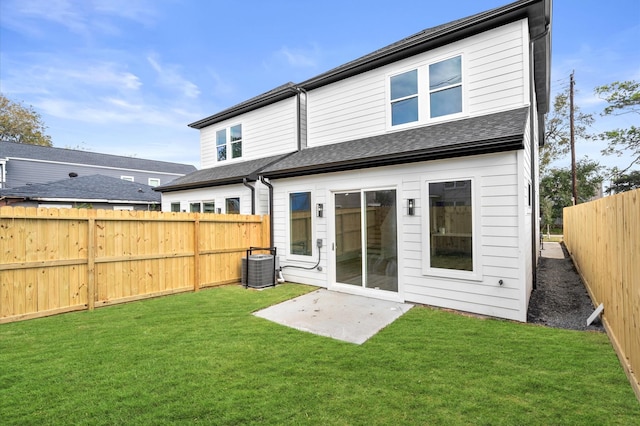 rear view of property featuring a yard and central AC unit