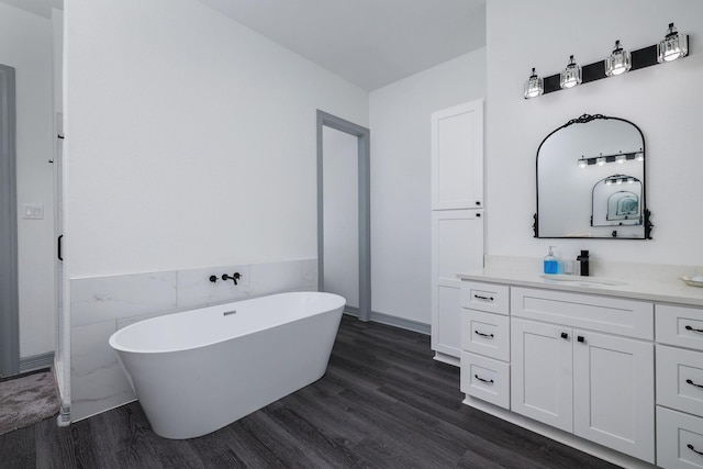 bathroom with a tub to relax in, hardwood / wood-style floors, and vanity