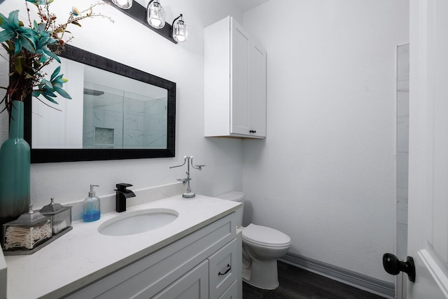 bathroom with wood-type flooring, vanity, toilet, and a shower with door