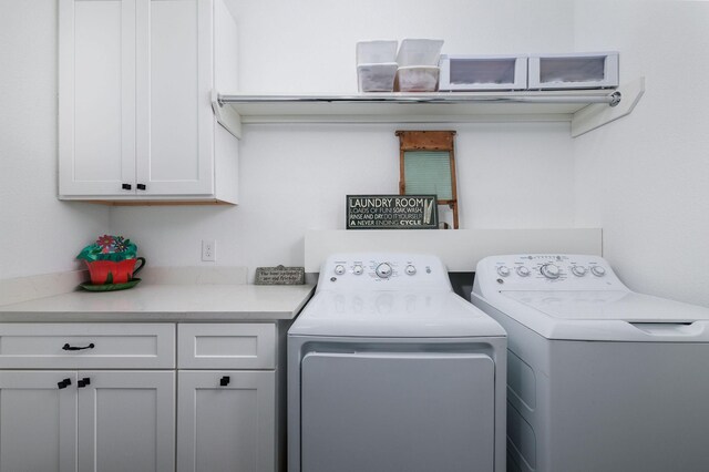 laundry room featuring washer and dryer and cabinets