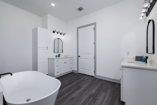 bathroom featuring hardwood / wood-style floors, vanity, and a tub