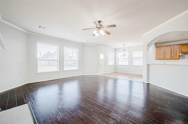 unfurnished living room with crown molding, ceiling fan with notable chandelier, hardwood / wood-style floors, and a textured ceiling