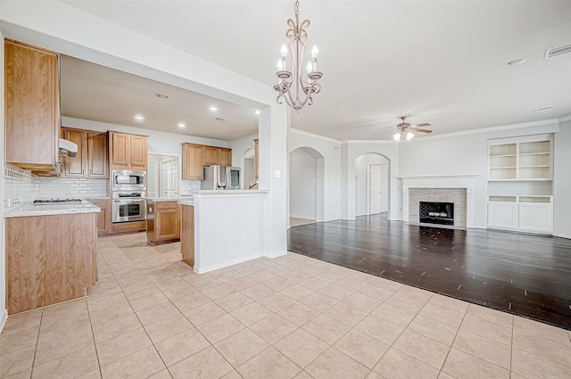 kitchen with stainless steel appliances, pendant lighting, light tile patterned floors, and decorative backsplash