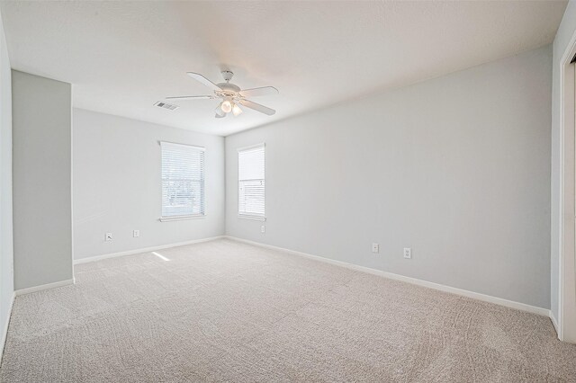 carpeted spare room with ceiling fan