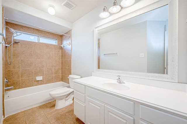 full bathroom featuring vanity, tile patterned flooring, tiled shower / bath combo, and toilet