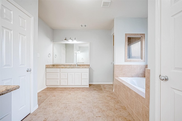 bathroom featuring vanity, tile patterned flooring, and tiled bath