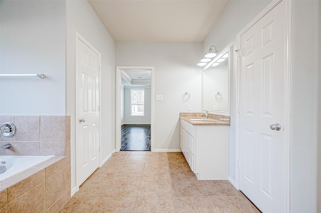 bathroom featuring vanity, tiled bath, and tile patterned flooring