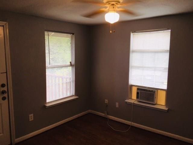 unfurnished room with ceiling fan, cooling unit, and dark wood-type flooring