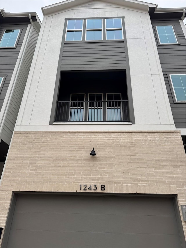 view of property exterior with a balcony and a garage