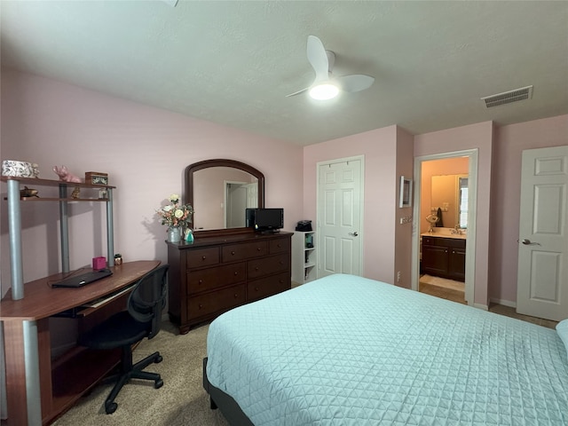 carpeted bedroom with ceiling fan and ensuite bathroom