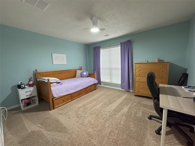 bedroom featuring ceiling fan, light colored carpet, and a textured ceiling