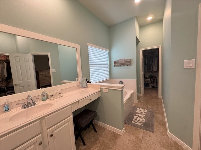 bathroom featuring tile patterned floors, vanity, and a relaxing tiled tub