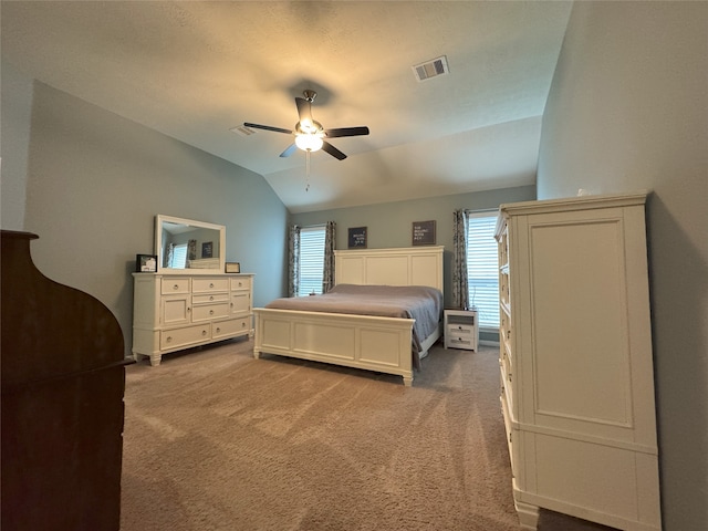 bedroom with ceiling fan, lofted ceiling, and carpet floors