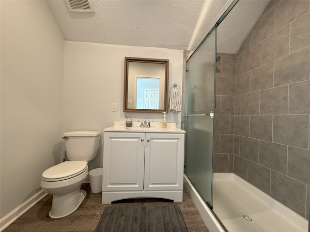 bathroom featuring vanity, hardwood / wood-style flooring, toilet, and walk in shower