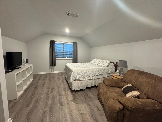 bedroom featuring hardwood / wood-style flooring and vaulted ceiling