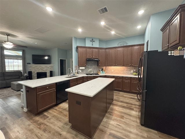 kitchen featuring ceiling fan, kitchen peninsula, dark brown cabinets, a kitchen island, and black appliances