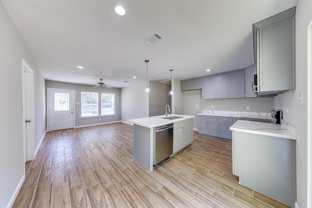 kitchen with appliances with stainless steel finishes, ceiling fan, sink, pendant lighting, and a center island with sink