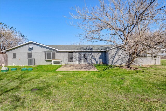 rear view of property featuring a lawn, central air condition unit, and a patio