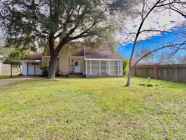 view of front of home with a front yard, a garage, and a sunroom