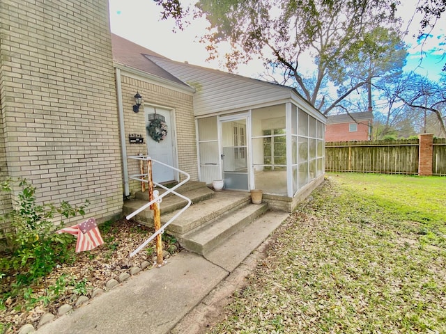 view of exterior entry with a yard