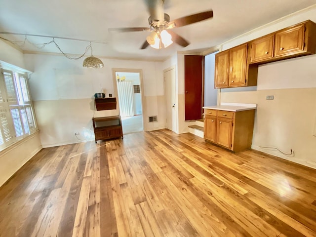 kitchen with hanging light fixtures, light hardwood / wood-style flooring, and ceiling fan