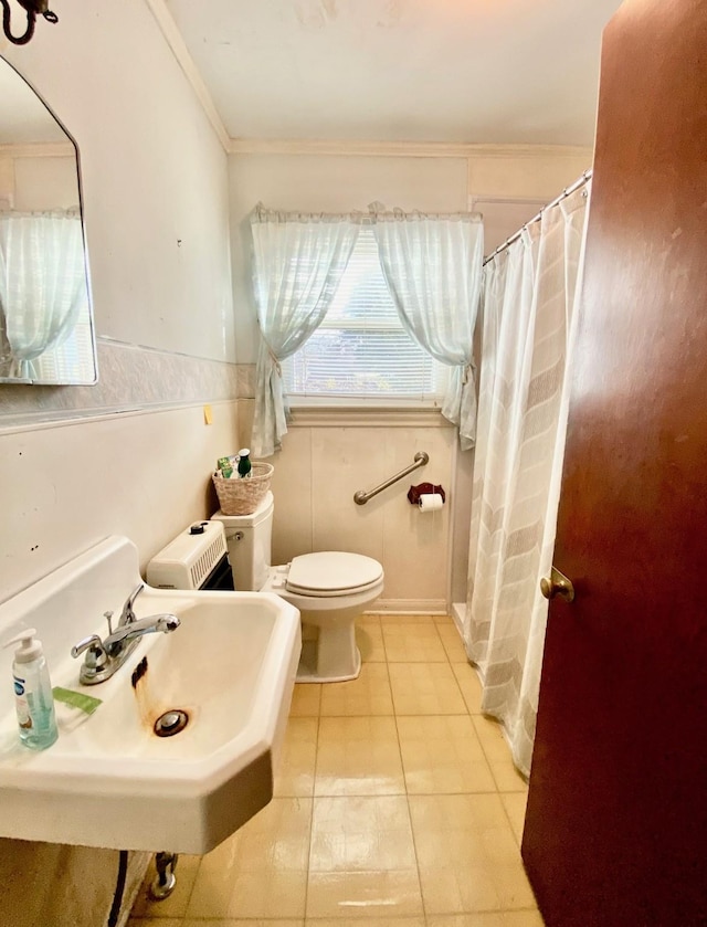 bathroom featuring tile patterned flooring, toilet, crown molding, and sink