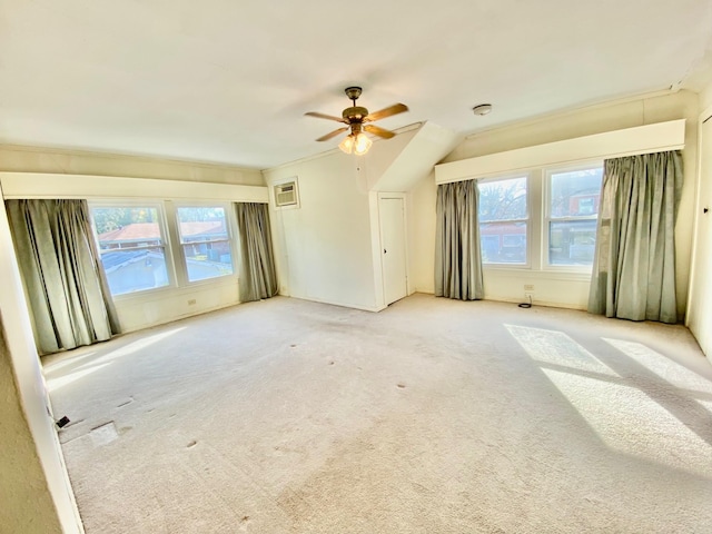 carpeted spare room featuring ceiling fan and a wall mounted AC