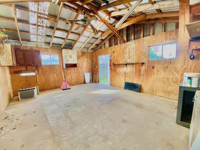 miscellaneous room featuring high vaulted ceiling, a wealth of natural light, and wood walls