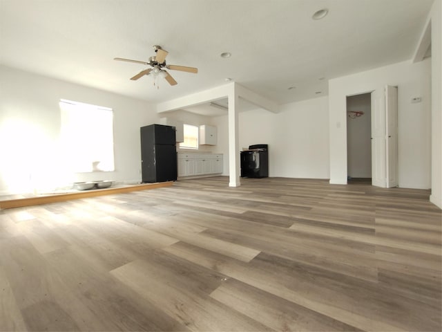 unfurnished living room with ceiling fan and hardwood / wood-style floors