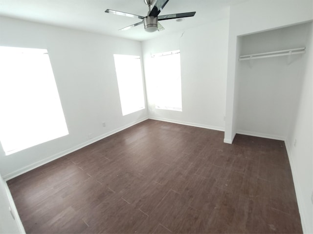 unfurnished bedroom with dark wood-type flooring, ceiling fan, and a closet