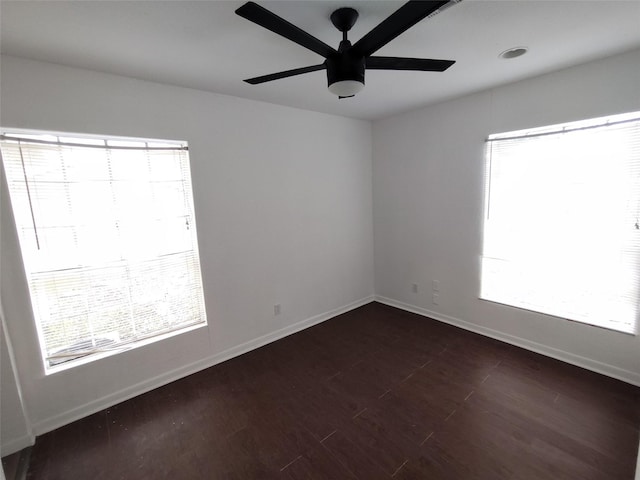 empty room with dark wood-type flooring and ceiling fan