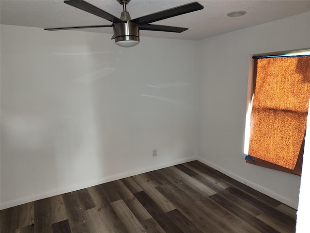 empty room with dark hardwood / wood-style flooring and ceiling fan