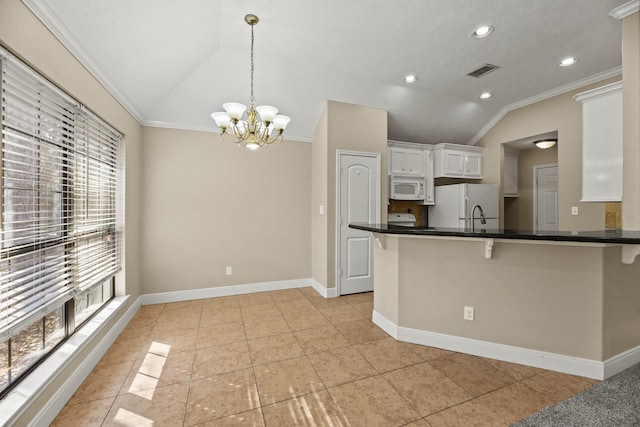 kitchen with pendant lighting, white cabinetry, white appliances, and vaulted ceiling