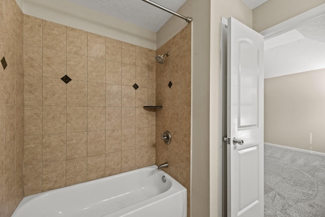 bathroom with a textured ceiling and tiled shower / bath