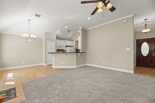 unfurnished living room featuring ornamental molding, ceiling fan with notable chandelier, lofted ceiling, and light tile patterned flooring