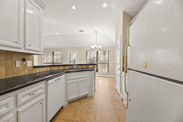 kitchen with white appliances, hanging light fixtures, sink, light tile patterned floors, and white cabinetry