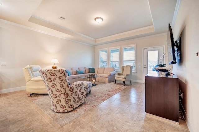 living room with a raised ceiling, ornamental molding, and light tile patterned floors